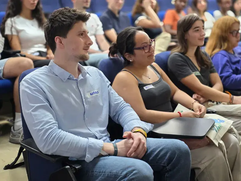 Estudiantes internacionales sentados en el auditorio mientras escuchan las palabras del rector